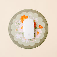 The-darling-effect’s Bouquet Beauty Sage Chic Clicks Mouse Pad pairs a white wireless mouse with a scalloped-edge pad featuring orange, pink, and white flowers on muted green—a charming upgrade for your workspace.
