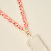 A close-up of The Darling Effect’s Duo Rose Hold the Phone Crossbody Chain, a light pink chunky lanyard attached to a wavy-edged white card holder—stylish and practical for your phone on the go.