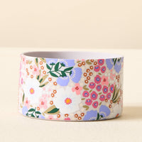 The Darling Effect Sweet Meadow Purple Tumbler Silicone Boot features a charming floral pattern with white, purple, and pink flowers plus green leaves—perfect to add flair as a No-Slip accessory for your tumbler.