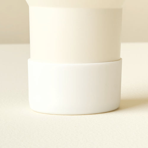 Close-up of The Darling Effect’s White Tumbler Silicone Boot on a pale cream tumbler, showing its no-slip protection and sleek two-toned design.
