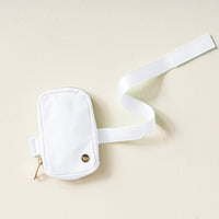 The Darling Effect White Tumbler Fanny Pack features a chic white design with a gold zipper and emblem, plus a long white strap—water-resistant and ideal for carrying essentials on daily adventures.