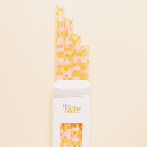 The Darling Effect Check Peach 40 oz Tumbler Straw Set features eco-friendly, reusable straws with a pink and yellow checkered pattern, packaged in a white box—perfect for your tumbler straw collection.