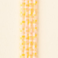 A vertical pattern of small rectangles in pastel yellow, pink, and cream on beige—ideal for presenting The Darling Effect’s Check Peach 40 oz Tumbler Straw Set.