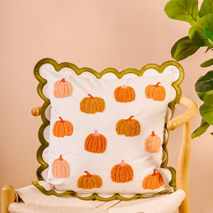 Pumpkin Patch Scalloped Square Throw Pillow with a scalloped green edge and a pattern of embroidered orange and pink pumpkins.