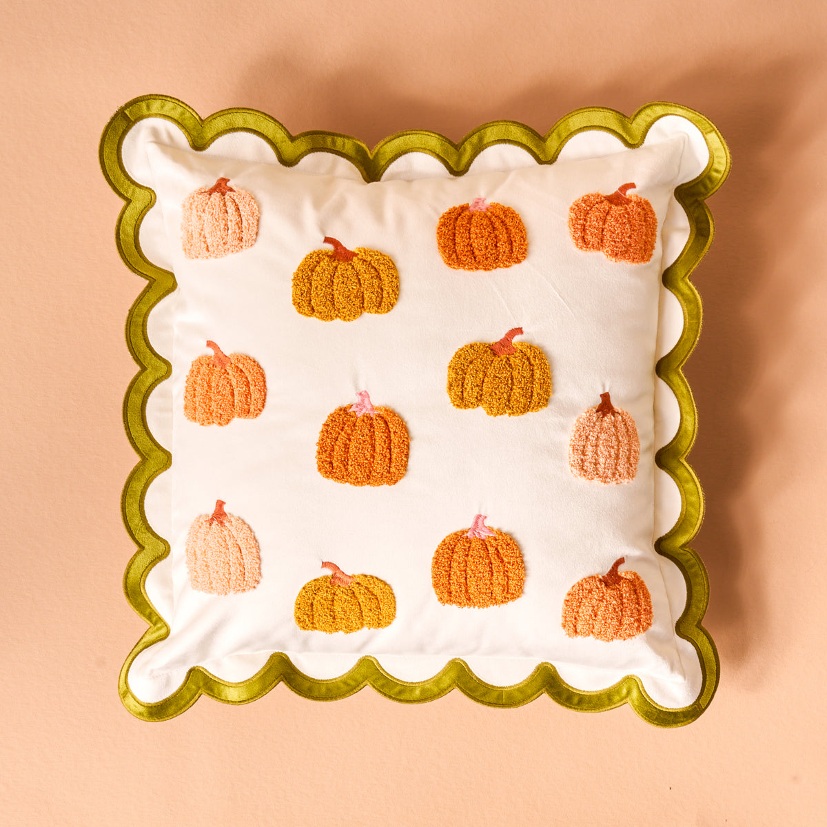 Pumpkin Patch Scalloped Square Throw Pillow with a green scalloped edge and a pattern of embroidered orange and peach pumpkins.