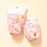 Two Ghost Party Sip Savvy Drink Sleeves by The Darling Effect, featuring pink neoprene with white, orange, and peach ghost and pumpkin designs, are shown on a beige background. Each has a white top label for a festive touch.