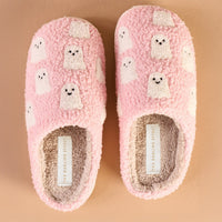 The Darling Effect Ghosts Fuzzy Slippers feature pink fuzz, white cartoon ghost designs, and cream insoles with a visible brand label—perfect fall-themed slippers shown side by side on a beige background.