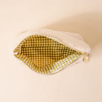 The Darling Effect's Apples & Pearls Teddy Pouch features a fluffy white sherpa exterior, green gingham lining, and gold zipper—making it the perfect fall accessory for your cosmetics.