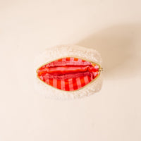 The Darling Effect's Square Candy Corn Cuties Teddy Pouch, made of small, white fluffy sherpa, is shown open from above to display its bright pink and red striped lining against a light background.