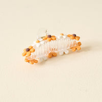 Add a cheerful touch to your Game Day look with The Darling Effect's Orange Game Day Daisy Claw Clip, featuring clear material and white and orange flowers with brown centers—perfect for showing off your school spirit.