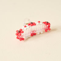 The Darling Effect's Red Game Day Daisy Claw Clip features red and white daisy-shaped charms with brown centers—a fun, spirited accessory to show off your school colors on Game Day.