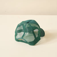 The Darling Effect's Green Game Day Trucker Hat features a solid fabric front, mesh back panel, and is ideal for showing team spirit on game day.