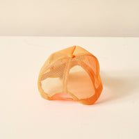 The Darling Effect's Orange Game Day Trucker Hat, perfect for showing team spirit, is pictured upside down on a white surface with a simple light background.