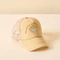 The Red Game Day Trucker Hat by The Darling Effect features a vibrant red mesh design with a heart patch on the front. “Tailgates & touchdowns” is embroidered above the heart, which includes “tailgates” stitched inside—perfect for showcasing your team spirit on game day. The hat is displayed on a cream-colored surface.