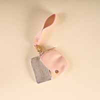 A pink wristlet strap connected to a small pink pouch and a silver rectangular pouch with a metallic mesh texture, forming The Darling Effect Rosé All Day Dynamic Duo Pouch Luxe Wristlet.