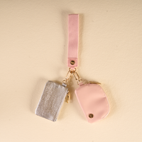 A Rosé All Day Dynamic Duo Pouch Luxe Wristlet featuring a rectangular silver zippered pouch and a semi-circular pink pouch, both accented with gold hardware and attached to a luxe wristlet strap.