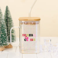 The Darling Effect’s Mama Claus Square Glass is a clear iridescent mug with a bamboo lid and glass straw, finished with “mama claus” in colorful text and small pink flowers.