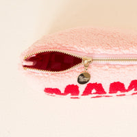 The Darling Effect's Mama Claus Teddy Pouch features soft pink fuzzy fabric, bold red "Mama Claus" lettering, gold zipper hardware with a round charm, and a red-lined interior—an ideal travel accessory from the Christmas Teddy Pouches collection.