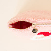 The Darling Effect's Dear Santa Teddy Pouch is a pink, textured cosmetics pouch with a gold zipper and circular pull engraved in cursive, revealing a pink checkered interior—ideal as a stylish travel accessory.