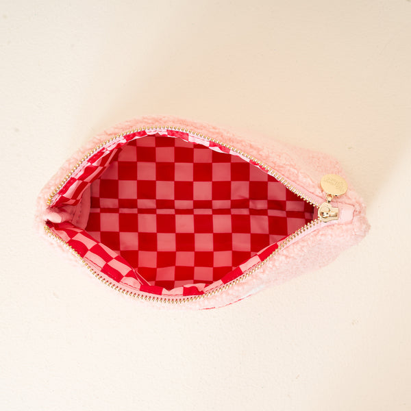 The Darling Effect's Dear Santa Teddy Pouch is a small pink zippered pouch with a fluffy exterior, gold charm, and red-pink checkered lining—perfect as a cute travel accessory or part of the Christmas Teddy Pouches collection.
