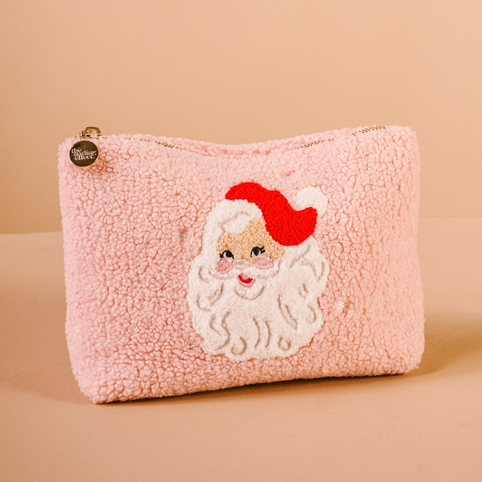 The Darling Effect's Dear Santa Teddy Pouch features pink sherpa fabric, a zipper, and a Santa Claus patch with a red hat—perfect for holiday vibes or as a cute accessory pouch.