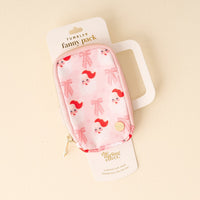 The Darling Effect's Dear Santa Tumbler Fanny Pack is a small, stylish pink pouch with Santa faces and bows, gold zipper, and attached to white packaging. Displayed on a light cream background.