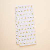 The-darling-effect's Handpicked For You Tea Towel is a neatly folded white cotton towel with small yellow and pink flowers and green leaves, shown on a light beige background.