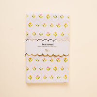The-darling-effect’s Handpicked For You Tea Towel features a folded cotton design with a yellow, pink, and green floral pattern, wrapped in a scalloped “tea towel” label—an ideal kitchen accent.