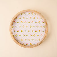 The-darling-effect’s Handpicked For You Large Round Wood Enamel Tray features a white base with colorful floral and green leaf patterns, set against a light beige background for a decorative touch.
