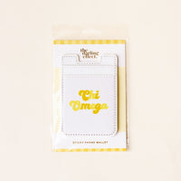 The Darling Effect Chi Omega Stick-On Phone Wallet comes in packaging with a striped yellow and white background, featuring “Chi Omega” in bold yellow letters on the front of the white wallet—a perfect sorority phone wallet or thoughtful gift for a Chi Omega sister.