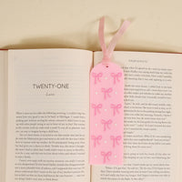 The Bows Pink Acrylic Bookmark by the-darling-effect features a light pink design with cute bows and white dots plus a ribbon—perfect for book lovers or as a charming gift.