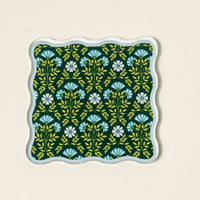 The Darling Effect’s Everbloom Forest Green Table Talk Acrylic Coaster Set comes in a square tray with wavy edges and a floral design—ideal for displaying coasters or adding charm to your table décor.