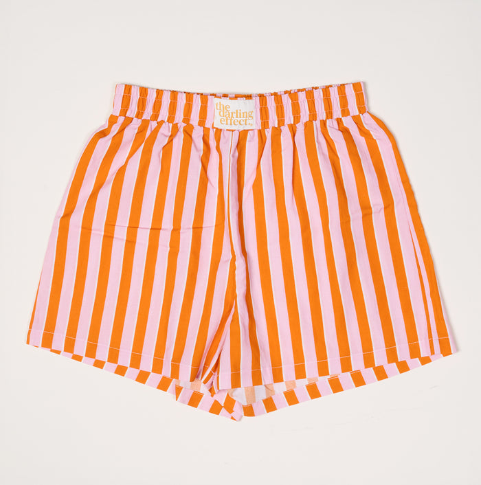The Darling Effect's Sicily Stripes Pink All Day Boxer Shorts feature bold orange and light pink vertical stripes on white, a relaxed fit, elastic waistband, and breathable fabric for comfort.