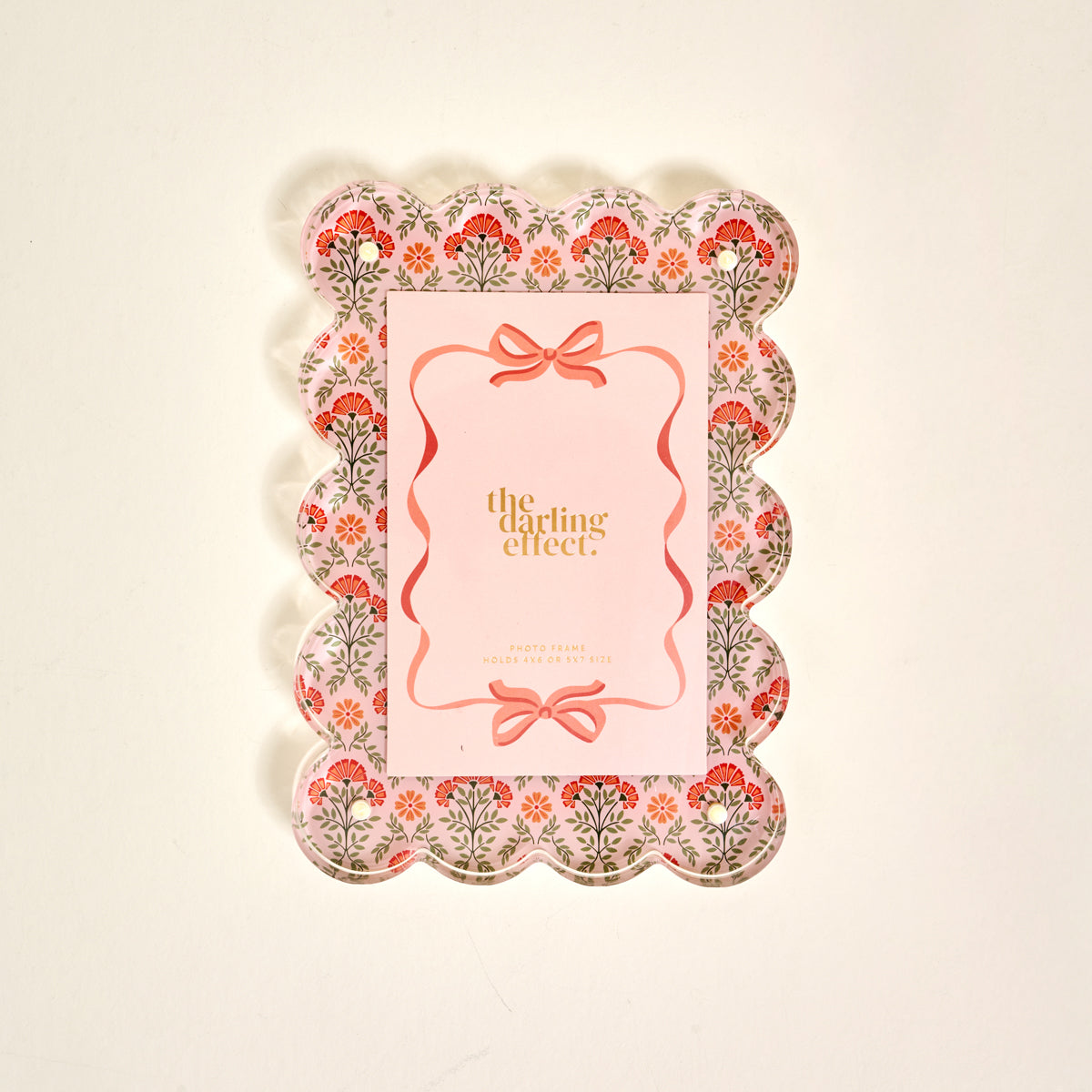 The Darling Effect’s Everbloom Dusty Rose Rectangle Scalloped Acrylic Picture Frame features pink, red, and green floral patterns and a pink center—perfect for anyone who loves stylish, modern frames.