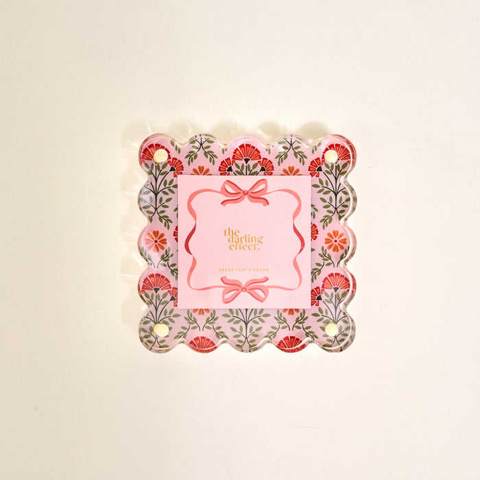The Everbloom Dusty Rose Little Moments Acrylic Picture Frame by The Darling Effect features a square notepad with scalloped edges, pink floral border, corner holes, and gold "the sterling effect" text on cream, set in an elegant acrylic frame.