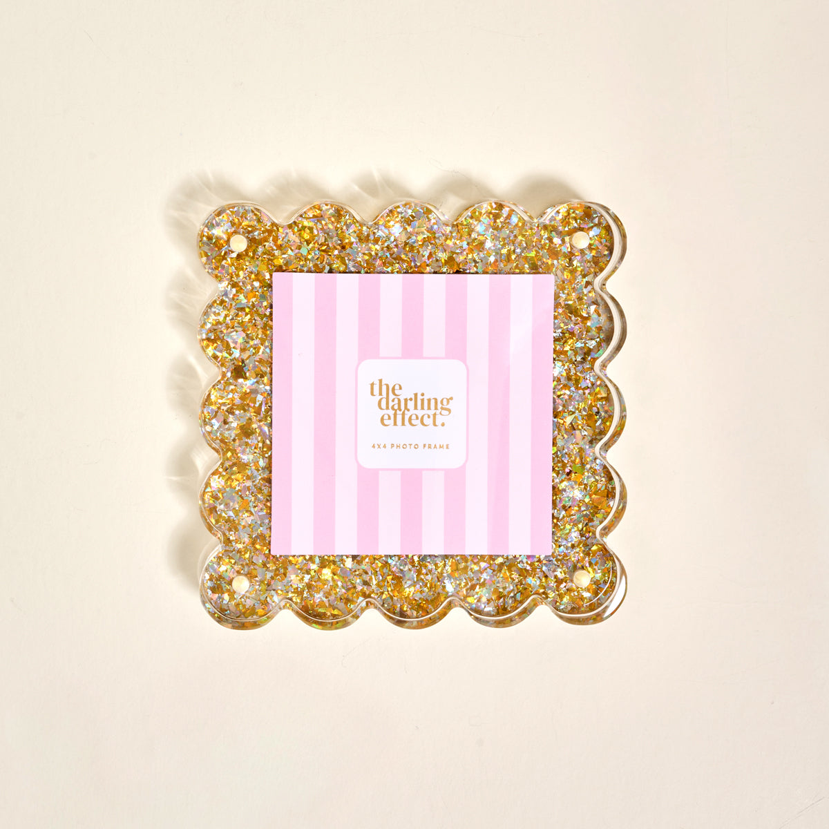 The Darling Effect's Gold Glitter Square Scalloped Acrylic Picture Frame features gold sparkles and a pink and white striped insert—an adorable, modern way to display your favorite memories.