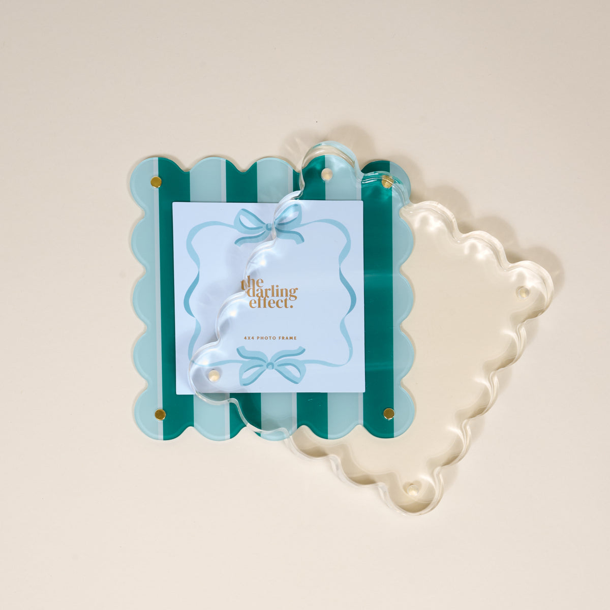The Darling Effect Sicily Stripes Teal Square Scalloped Acrylic Picture Frame features green and light blue stripes, a clear acrylic overlay, and ribbon and bow details—a modern way to showcase your favorite memories.