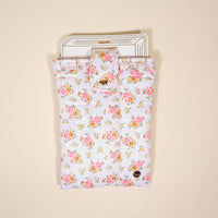 The Endless Daydream Cream Book Cover by the-darling-effect is a white quilted pouch with pink and yellow flowers, gold button clasp, and heart charm—perfect as a cute book sleeve or for holding cards and envelopes.