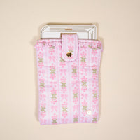 The Darling Effect's Oh So Fancy Pink Book Cover features a puffy polyester design with floral and bow patterns, snap button closure, and stylish protection for your e-reader or tablet—shown here against a plain beige background.