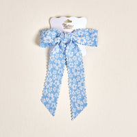 The Blue Flower Scallop Hair Bow by the-darling-effect features a blue floral pattern with scalloped edges and comes on a white hang tag with the brand’s gold logo—an adorable addition to your hair accessory collection.