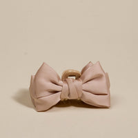 The Darling Effect's Beige Mini Satin Bow Claw Clip features a large, elegant satin bow—an elegant hair accessory displayed on a light beige background, perfect for any occasion.
