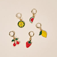 Five gold-colored keychains with vibrant fruit charms from The Darling Effect's Fruit Frenzy The Ultimate Charm Pack are arranged on a light beige background, perfect for enhancing your charm pack or scrunchie charm sets.