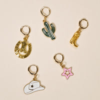 The Darling Effect's Giddy Up The Ultimate Charm Pack features five gold-toned hoop earrings with unique charms—horseshoe, cactus, cowboy boot, cowboy hat, and pink star—perfect for pairing with your statement necklaces.