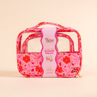 The Darling Effect's Poppin' Petals Hot Pink Clearly Chic Cosmetic Bag Set features clear panels, two zippered compartments, a top handle, and ships with packaging labeled "the darling effect clearly chic cosmetic bag set.