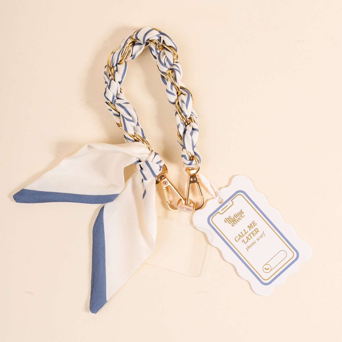 The Darling Effect's Bluebell Stripe Call Me Later Phone Scarf features a blue and white striped scarf, gold hardware, a braided keychain, and a scalloped white tag with “Call Me Later” in gold—an adorable accessory for your keys.
