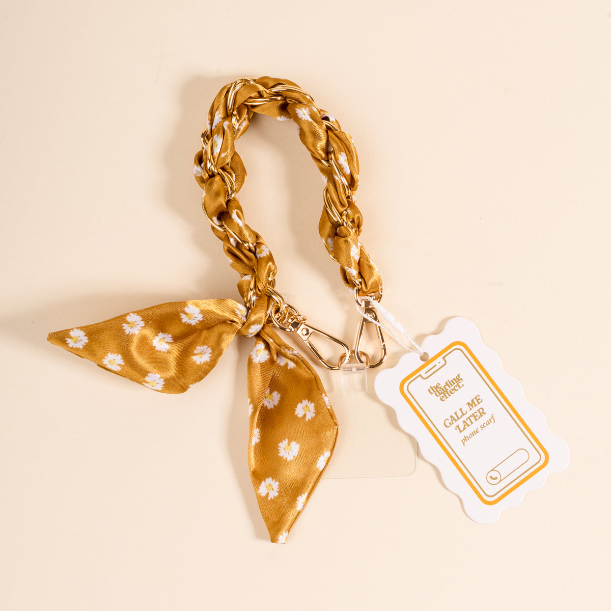 The Darling Effect's Honey Blossom Call Me Later Phone Scarf features a gold and white floral fabric keychain with braided loop, a matching knotted phone scarf, metal clip, and a white CALL ME tag for your number.