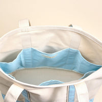 Top view of The Darling Effect’s Light Blue The Signature Canvas Tote Bag, featuring durable handles and a light blue interior with multiple compartments perfect for organizing everyday essentials.