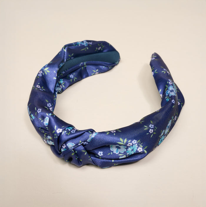 The Darling Effect's Endless Daydream Navy Classic Twist Headband features a blue and white floral print with a knot detail, making it a versatile hair accessory for any occasion.