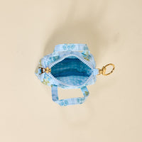 The Darling Effect’s Oh So Fancy Blue Itty Bitty Duffle Bag Charm features a light blue quilted floral pattern, gingham lining, gold zipper, and clip—perfect as a unique bag accessory or quilted charm.