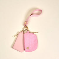 The Darling Effect’s Blush Dynamic Duo Pouch Luxe Wristlet features two small pink zippered pouches—one smooth, one woven with a gold logo—plus gold hardware and a matching wristlet strap for a chic, hands-free accessory.